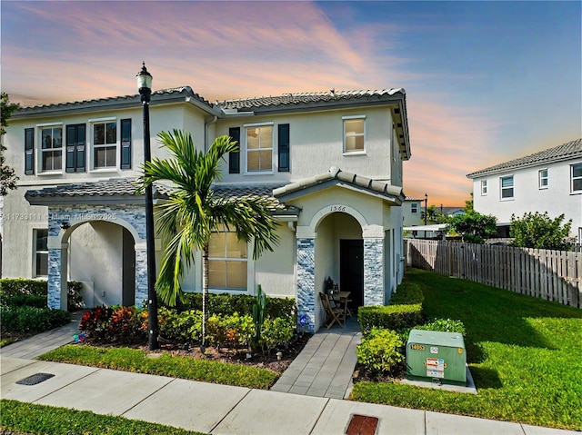 mediterranean / spanish-style house with a lawn