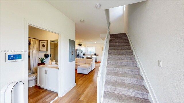 stairway with sink and hardwood / wood-style floors