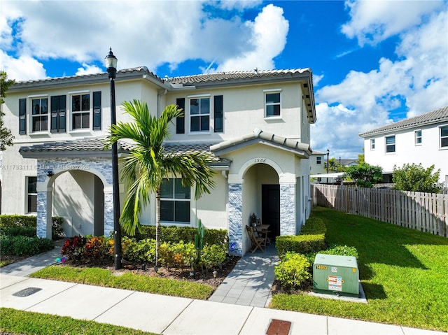 mediterranean / spanish home featuring a front lawn