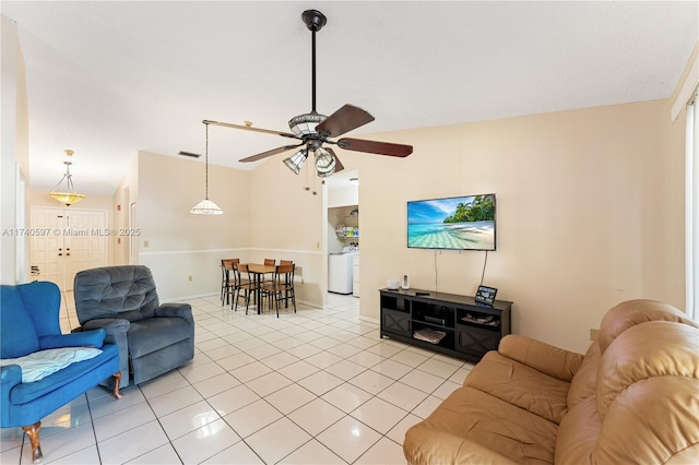 living room with washer / dryer, light tile patterned flooring, vaulted ceiling, and ceiling fan