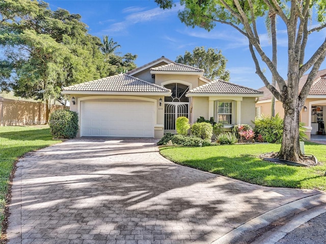 mediterranean / spanish-style house featuring a garage and a front lawn