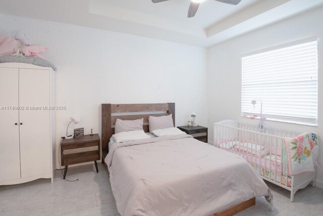 bedroom featuring ceiling fan and a tray ceiling