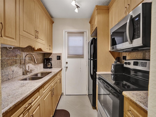 kitchen featuring light stone counters, sink, light tile patterned floors, and appliances with stainless steel finishes