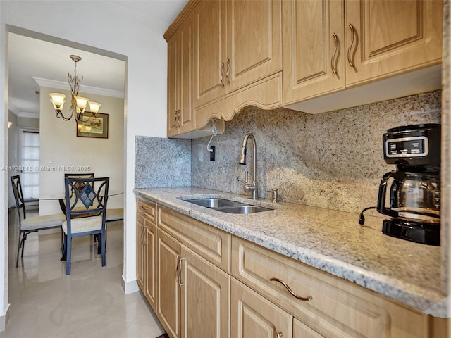 kitchen with sink, backsplash, hanging light fixtures, ornamental molding, and an inviting chandelier