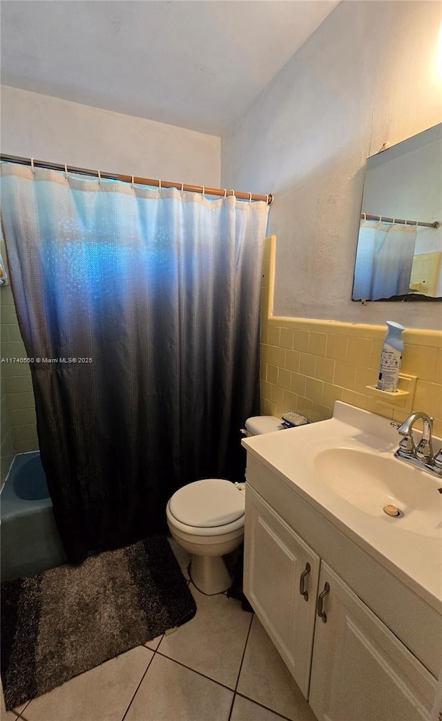 full bathroom with shower / bathtub combination with curtain, tile walls, vanity, tile patterned floors, and toilet