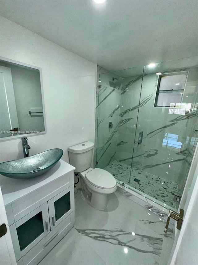 bathroom featuring vanity, an enclosed shower, and toilet