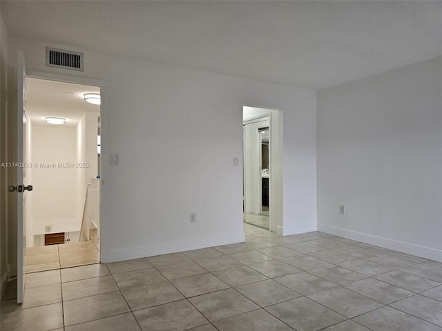 empty room featuring light tile patterned floors and a textured ceiling