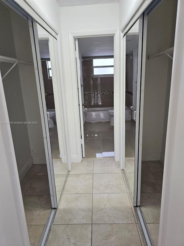 corridor featuring light tile patterned flooring