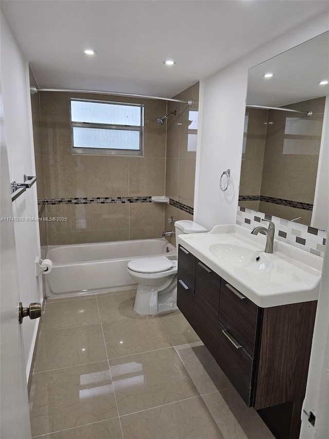 full bathroom with backsplash, vanity, tiled shower / bath, tile patterned floors, and toilet