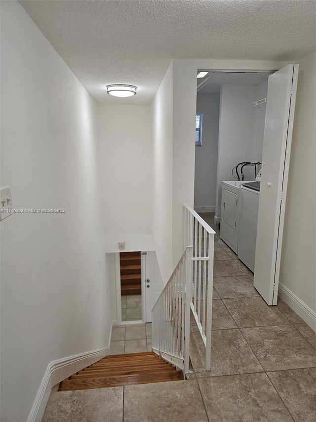 stairs featuring separate washer and dryer and a textured ceiling