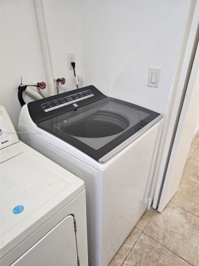 washroom featuring washing machine and dryer and light tile patterned floors