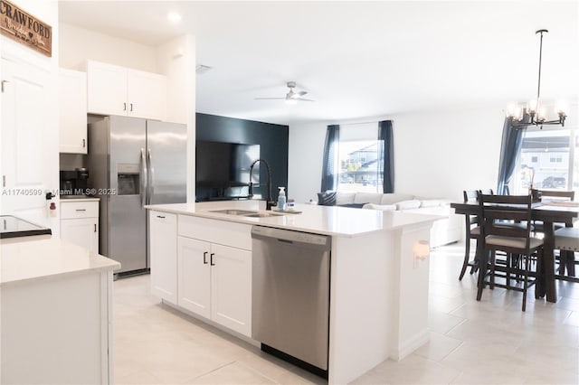 kitchen with stainless steel appliances, light countertops, a sink, and white cabinetry