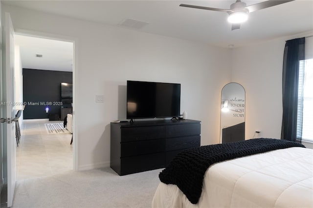 bedroom featuring light carpet, baseboards, visible vents, and a ceiling fan