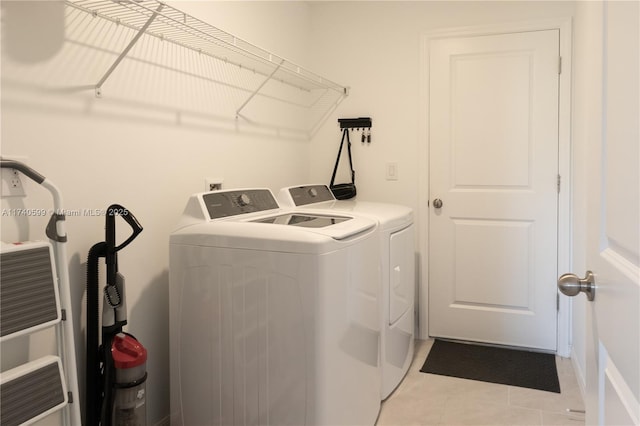 washroom featuring washer and dryer and light tile patterned flooring