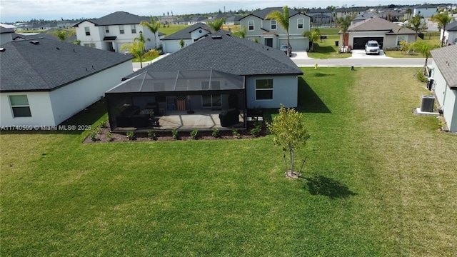 rear view of house with a lanai, a patio area, a residential view, and a yard