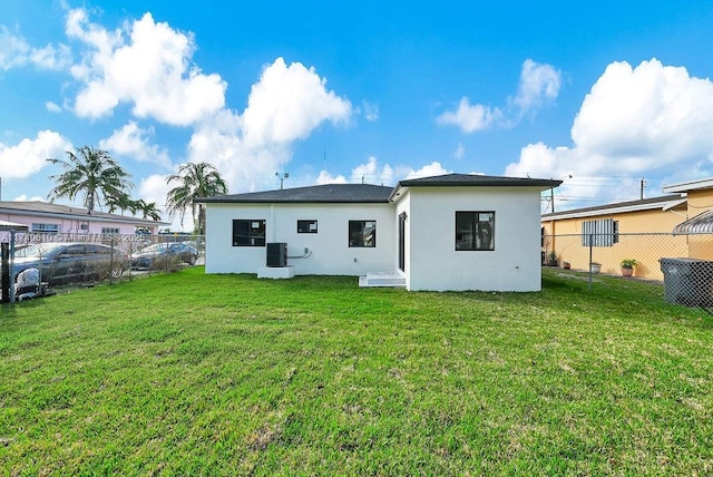 back of property featuring cooling unit and a lawn