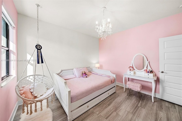 bedroom with a notable chandelier and light wood-type flooring