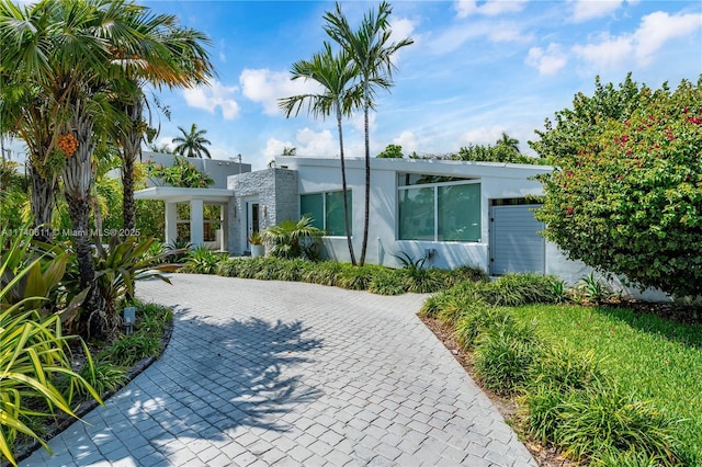 view of front of home with decorative driveway and stucco siding