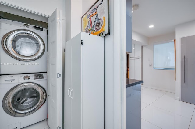 clothes washing area featuring laundry area, recessed lighting, light tile patterned floors, and stacked washer / dryer