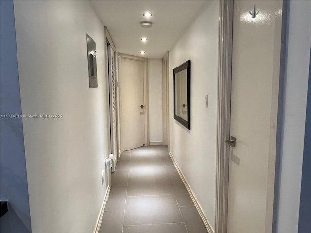 hallway with dark tile patterned flooring