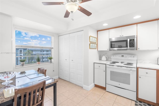 kitchen featuring white electric range, white cabinets, ceiling fan, and light tile patterned floors