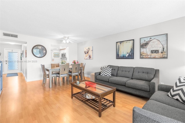 living room with hardwood / wood-style flooring and a textured ceiling