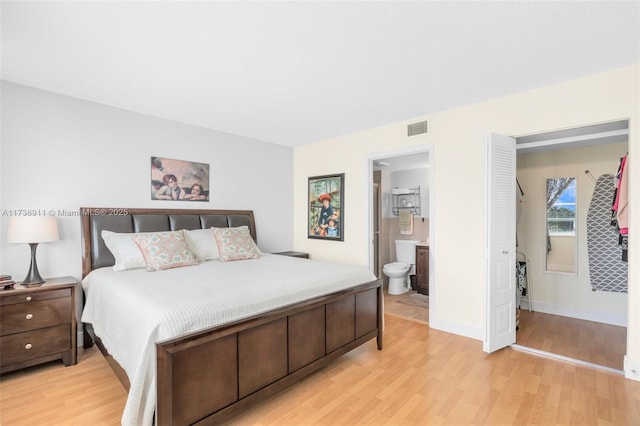 bedroom featuring connected bathroom and light hardwood / wood-style floors