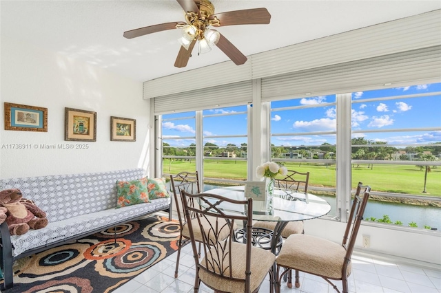 sunroom / solarium featuring a water view and ceiling fan