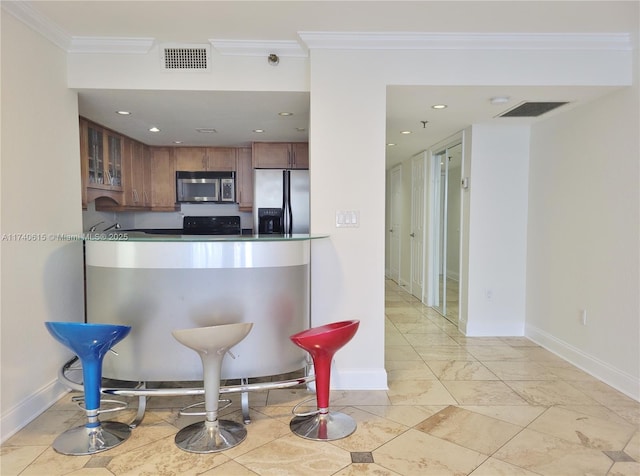 kitchen with ornamental molding and appliances with stainless steel finishes