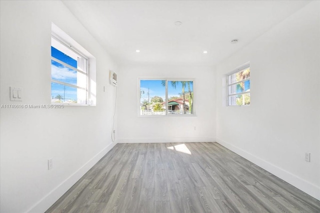 empty room with light hardwood / wood-style floors and a wealth of natural light