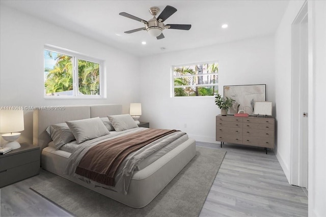 bedroom with multiple windows, ceiling fan, and light wood-type flooring