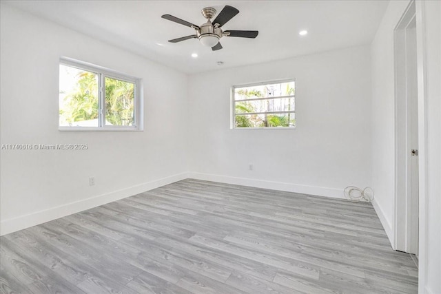 empty room with ceiling fan and light hardwood / wood-style floors