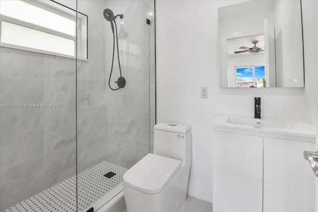 bathroom with a healthy amount of sunlight, vanity, toilet, and tiled shower