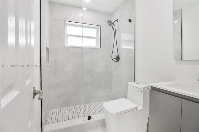 bathroom featuring vanity, tiled shower, and toilet