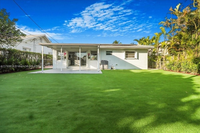 rear view of house with central AC unit, a patio area, and a lawn