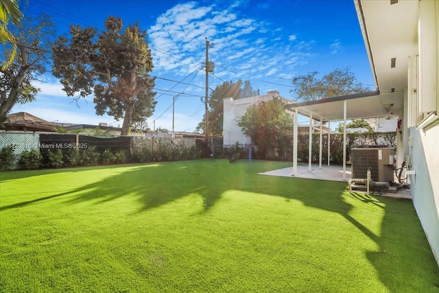 view of yard with central AC unit and a patio