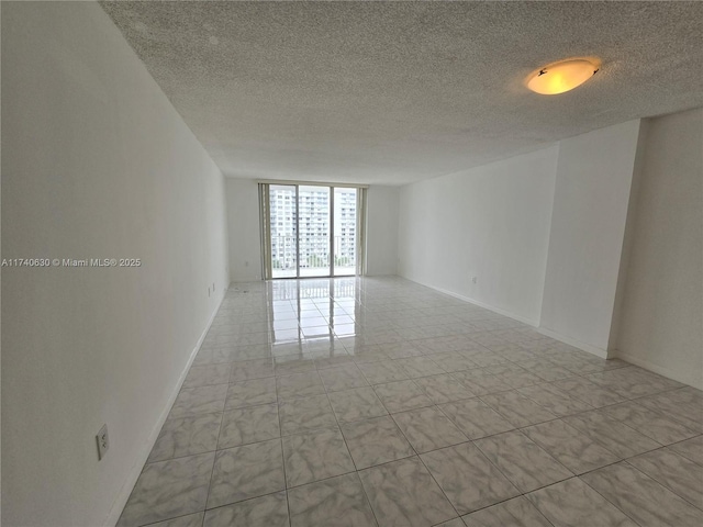 empty room featuring expansive windows and a textured ceiling