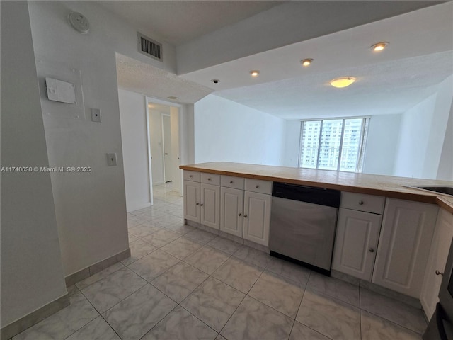 kitchen featuring white cabinetry, tile countertops, and stainless steel dishwasher