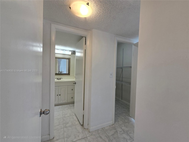 corridor featuring sink and a textured ceiling