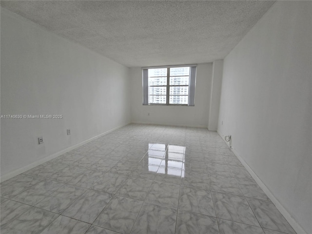 unfurnished room with a textured ceiling