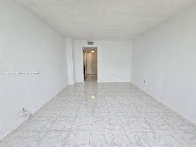 unfurnished room featuring a textured ceiling