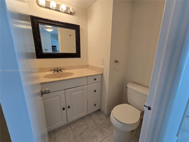 bathroom featuring tile patterned floors, vanity, and toilet