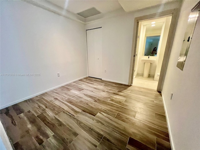 empty room with sink and light hardwood / wood-style floors