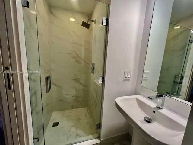 bathroom with sink and a shower with door