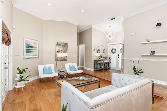 living room featuring a notable chandelier, crown molding, and light wood-type flooring