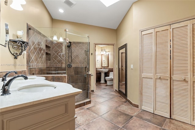 bathroom with walk in shower, toilet, a bidet, vanity, and tile patterned flooring