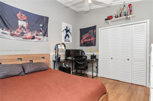 bedroom featuring wood-type flooring, ornamental molding, a closet, and ceiling fan