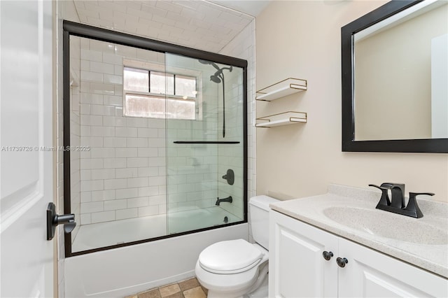 full bathroom featuring vanity, bath / shower combo with glass door, and toilet