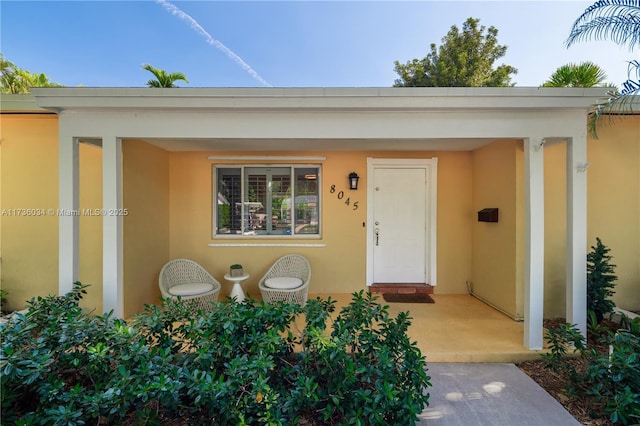 view of exterior entry featuring a patio area