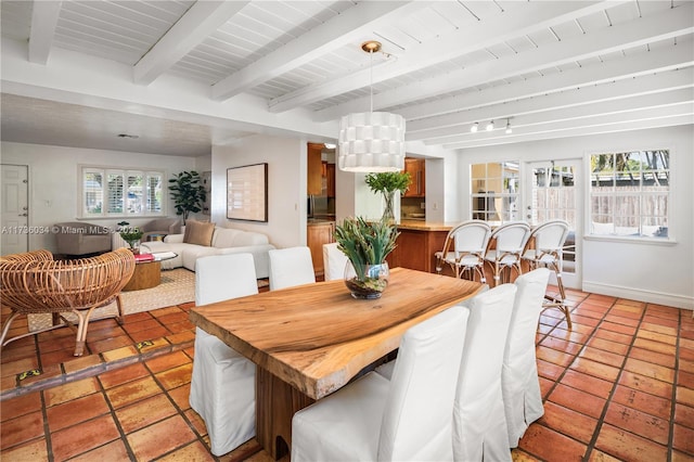 dining room with wood ceiling, light tile patterned floors, beam ceiling, and a healthy amount of sunlight